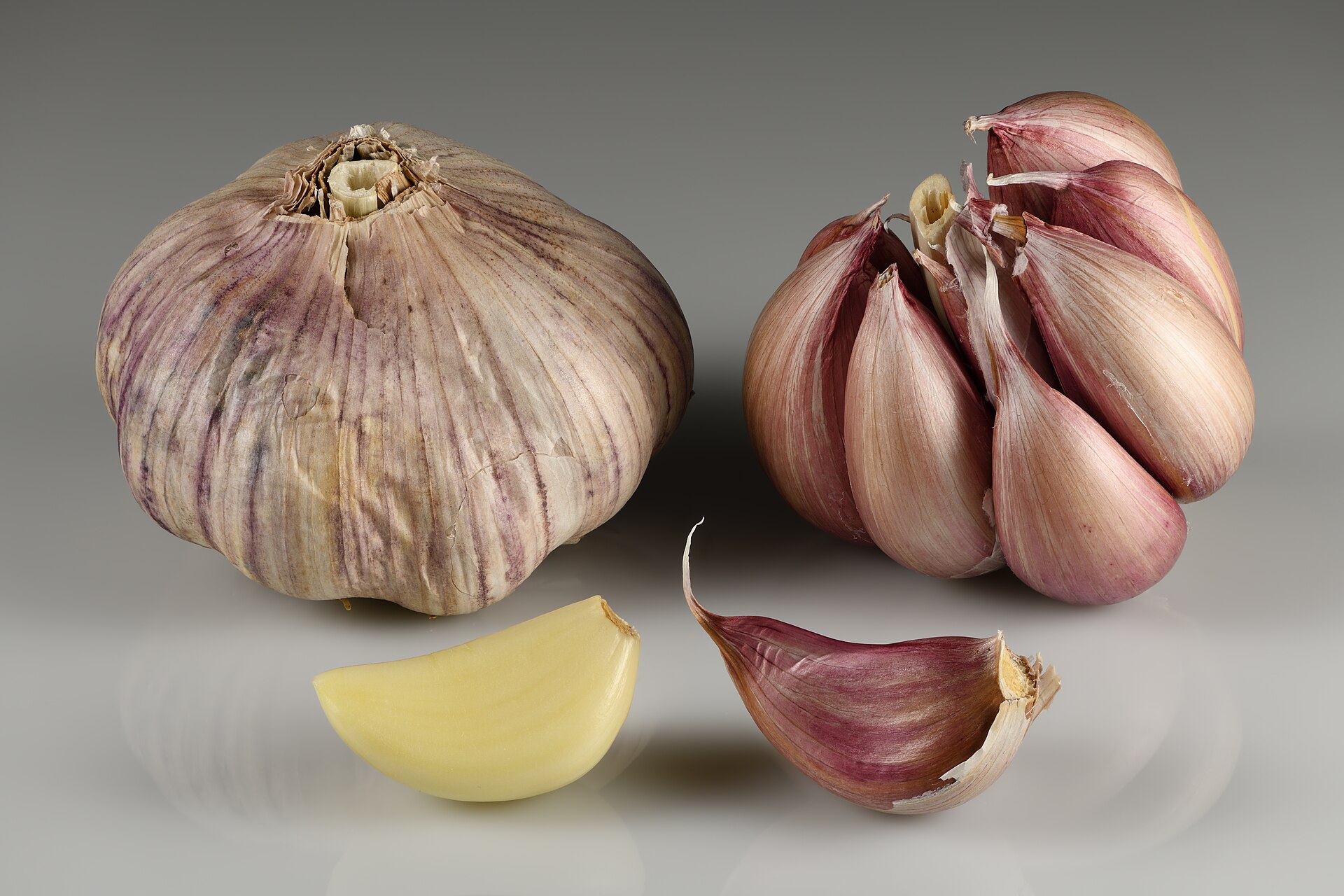 Bulbes d'ail et gousses posés sur une surface claire